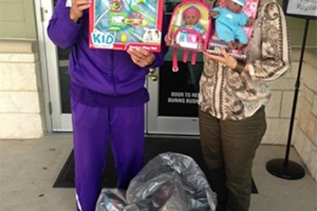 Employees holding toys Pinnacle Employees Display Items From The Line Dance Toy Drive